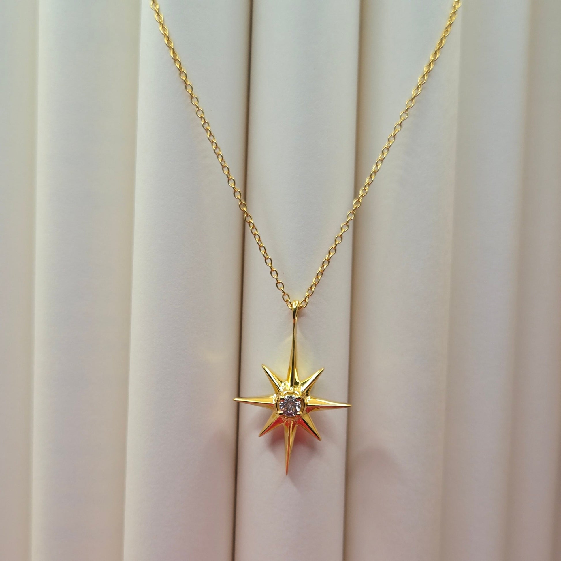 Gold-plated chain necklace featuring an eight-point starburst pendant with a clear faceted crystal at the center, offering a celestial and minimal everyday style