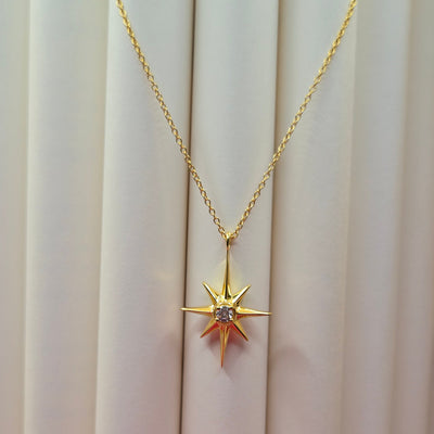 Gold-plated chain necklace featuring an eight-point starburst pendant with a clear faceted crystal at the center, offering a celestial and minimal everyday style