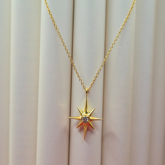 Gold-plated chain necklace featuring an eight-point starburst pendant with a clear faceted crystal at the center, offering a celestial and minimal everyday style
