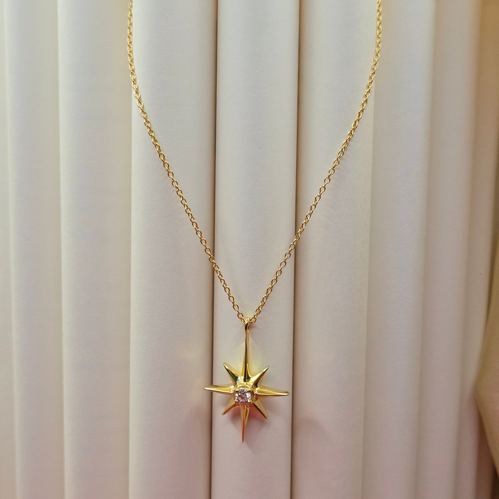 Gold-plated chain necklace featuring an eight-point starburst pendant with a clear faceted crystal at the center, offering a celestial and minimal everyday style