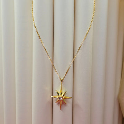 Gold-plated chain necklace featuring an eight-point starburst pendant with a clear faceted crystal at the center, offering a celestial and minimal everyday style