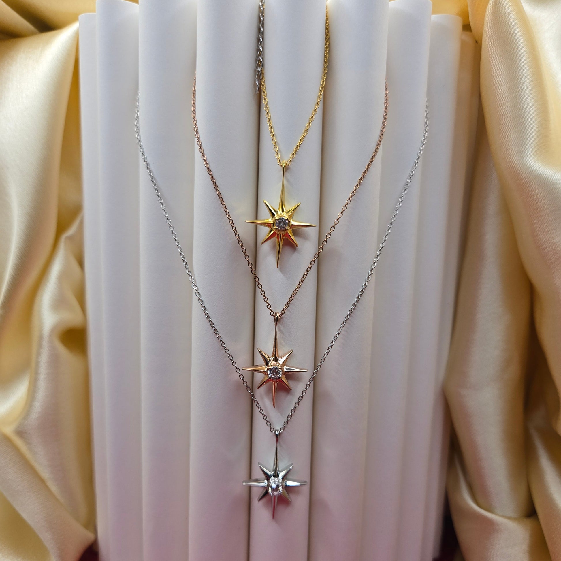 Gold, rose gold, rhodium plated chain necklace featuring an eight-point starburst pendant with a clear faceted crystal at the center, offering a celestial and minimal everyday style