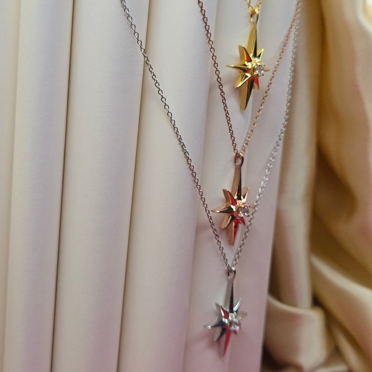Gold, rose gold, rhodium plated chain necklace featuring an eight-point starburst pendant with a clear faceted crystal at the center, offering a celestial and minimal everyday style