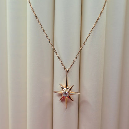 Rose gold, plated chain necklace featuring an eight-point starburst pendant with a clear faceted crystal at the center, offering a celestial and minimal everyday style