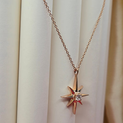 Rose gold, plated chain necklace featuring an eight-point starburst pendant with a clear faceted crystal at the center, offering a celestial and minimal everyday style