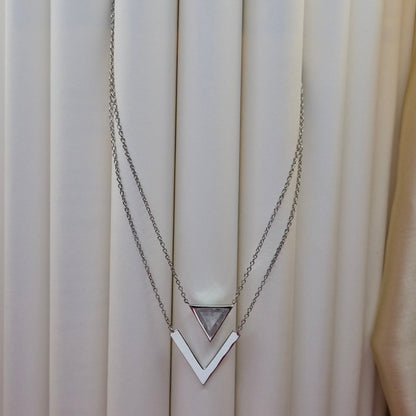Layered rhodium plated necklace featuring a clear triangular-cut stone pendant on the upper chain and a sleek V-shaped bar pendant on the lower chain, perfect for contemporary everyday styling.