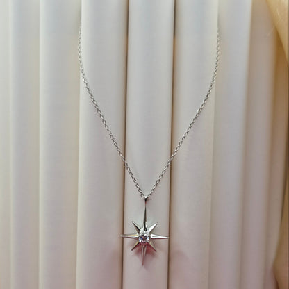 Rhodium plated chain necklace featuring an eight-point starburst pendant with a clear faceted crystal at the center, offering a celestial and minimal everyday style