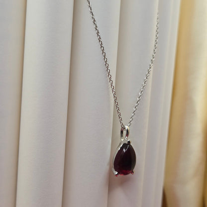 Rhodium plated chain necklace featuring a smooth teardrop-shaped deep maroon gemstone pendant, styled against a soft neutral backdrop for an elegant and minimal look.
