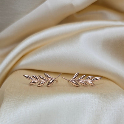 Silver leaf-shaped brooch on beige fabric