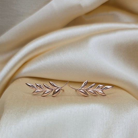 Silver leaf-shaped brooch on beige fabric