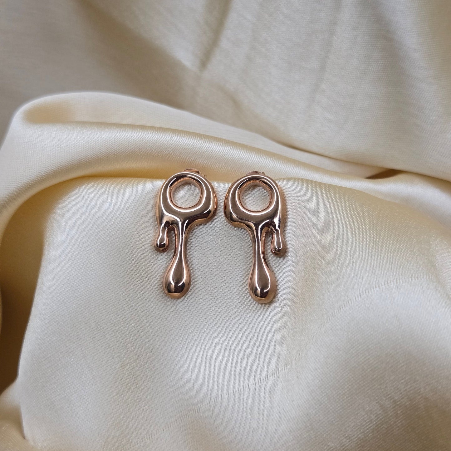 Art-inspired Rose-gold studs with a melted liquid metal form, offering bold yet elegant statement style for everyday and occasion wear.