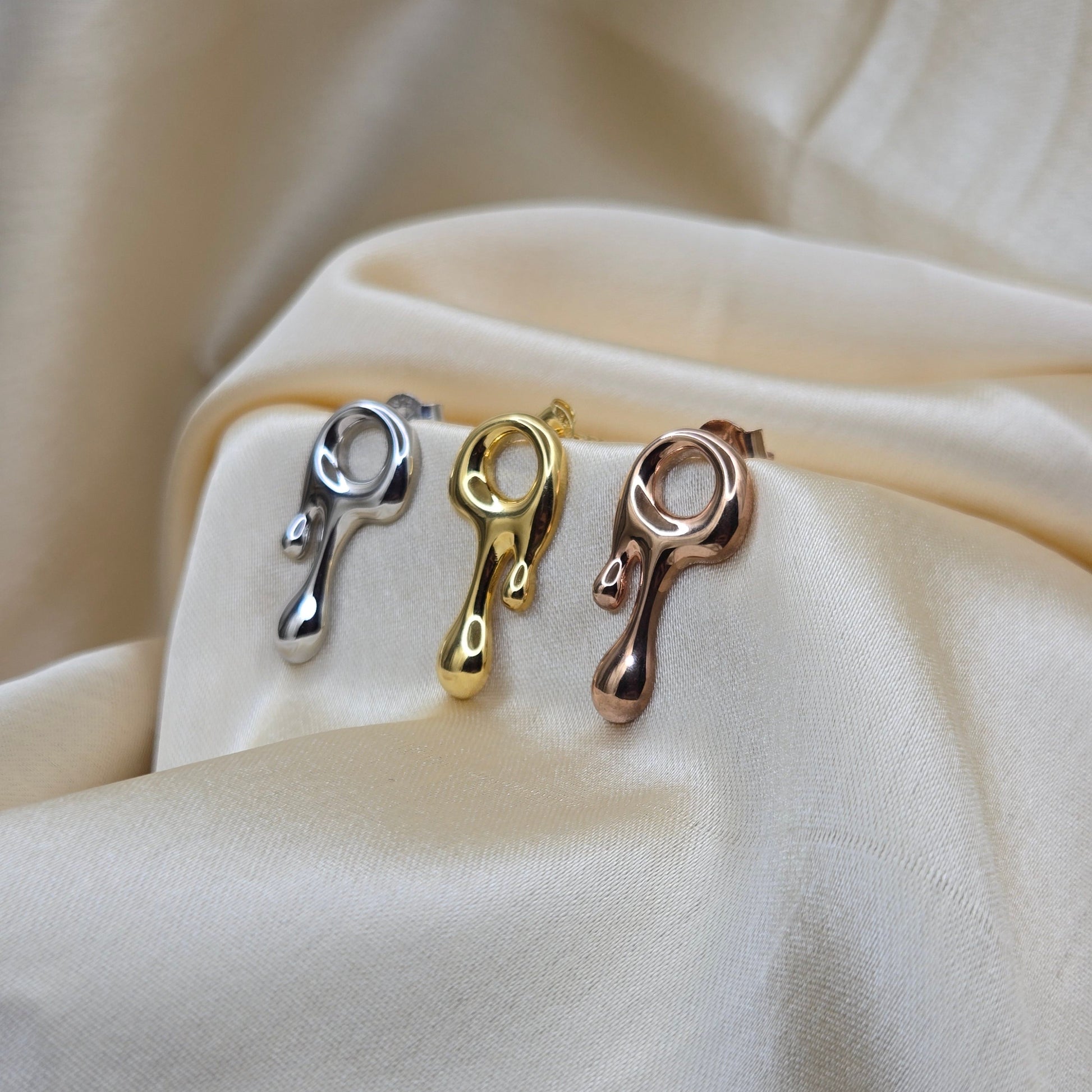 Art-inspired gold, rose-gold & rhodium studs with a melted liquid metal form, offering bold yet elegant statement style for everyday and occasion wear.