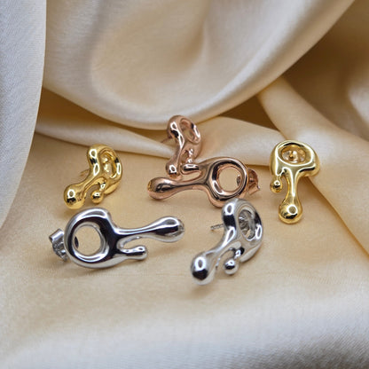 Art-inspired gold, rose-gold & rhodium studs with a melted liquid metal form, offering bold yet elegant statement style for everyday and occasion wear.