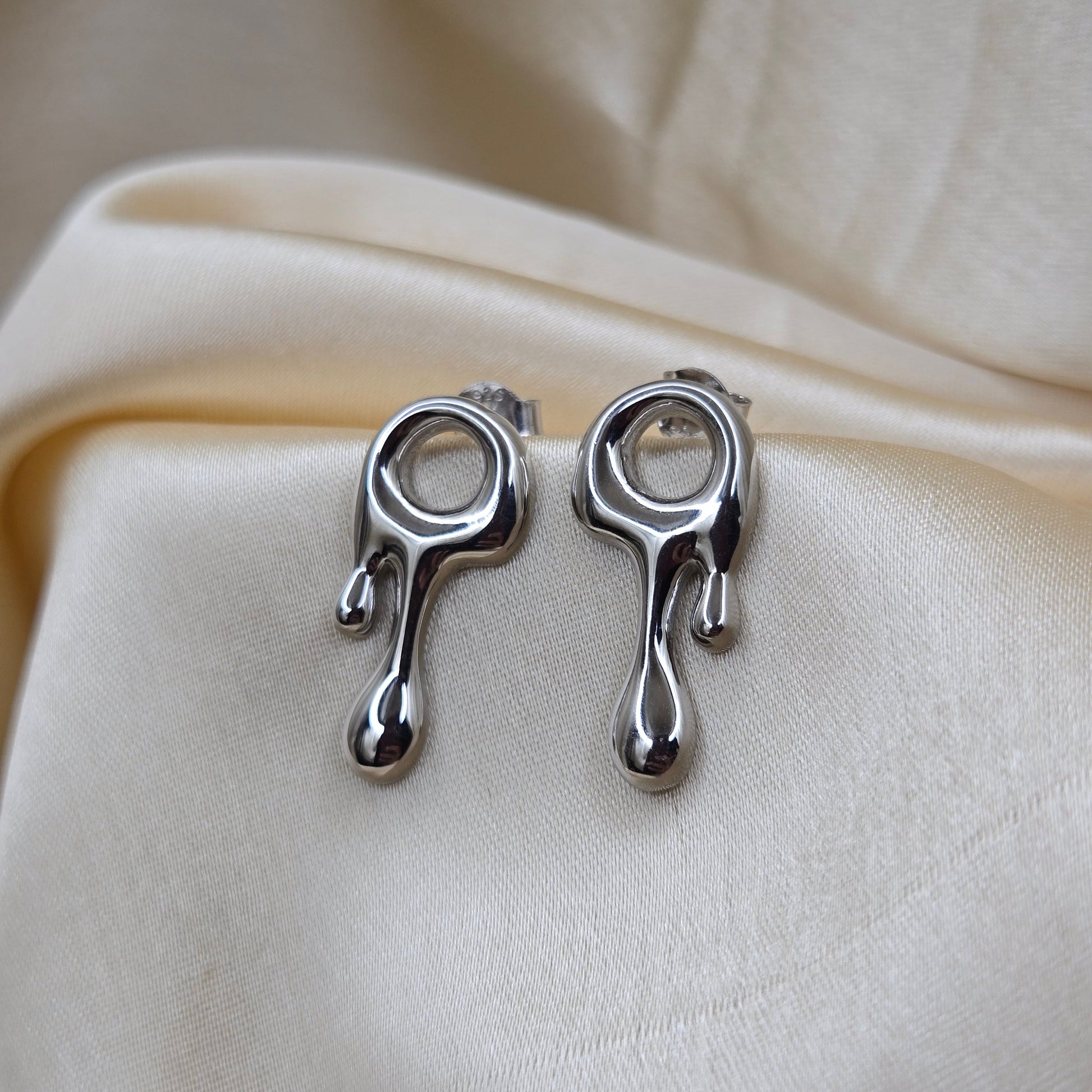 Art-inspired rodium studs with a melted liquid metal form, offering a bold yet elegant statement style for everyday and special occasions.