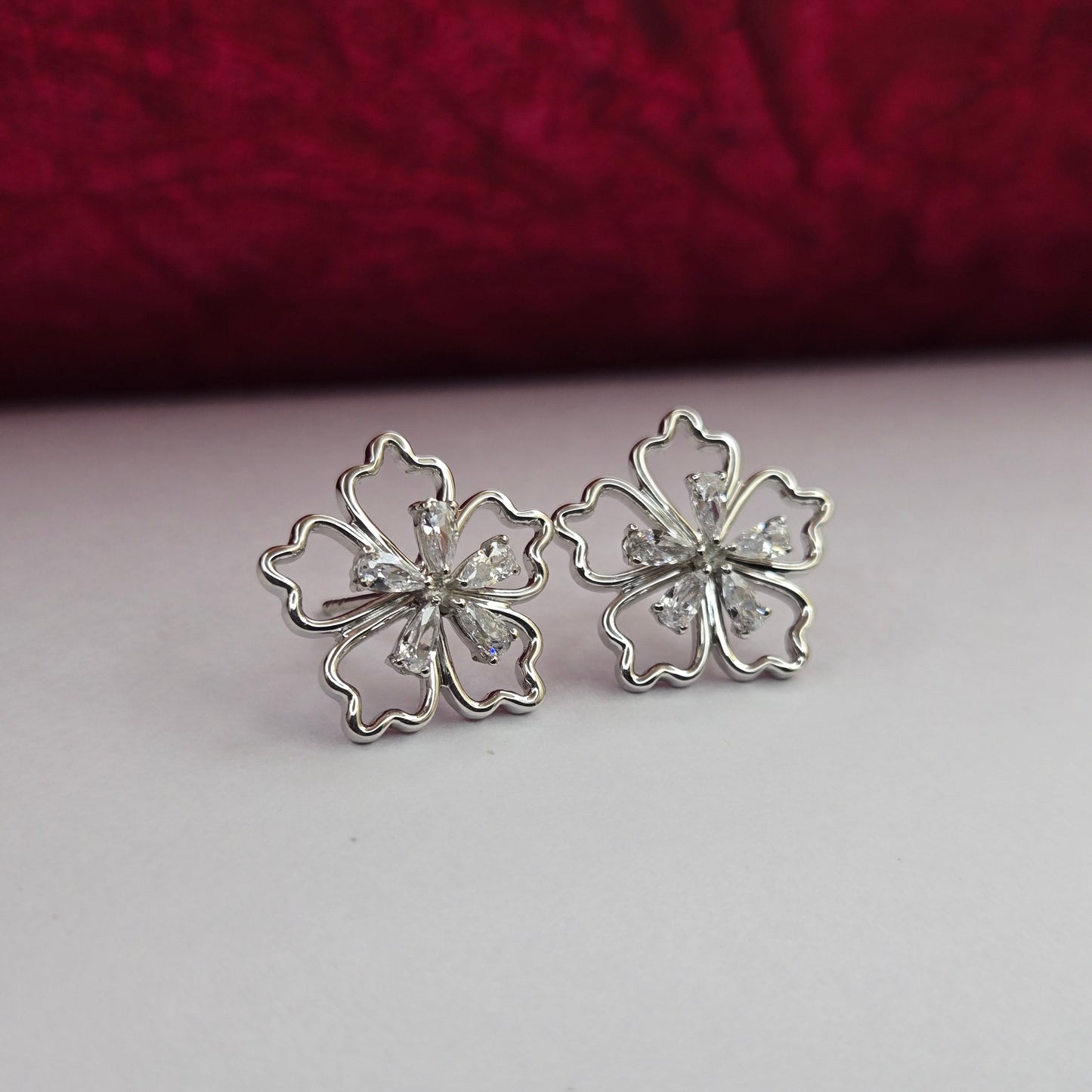 Rhodium-plated flower studs with shimmering crystal petals arranged in a symmetrical bloom design, suitable for both casual and festive styling