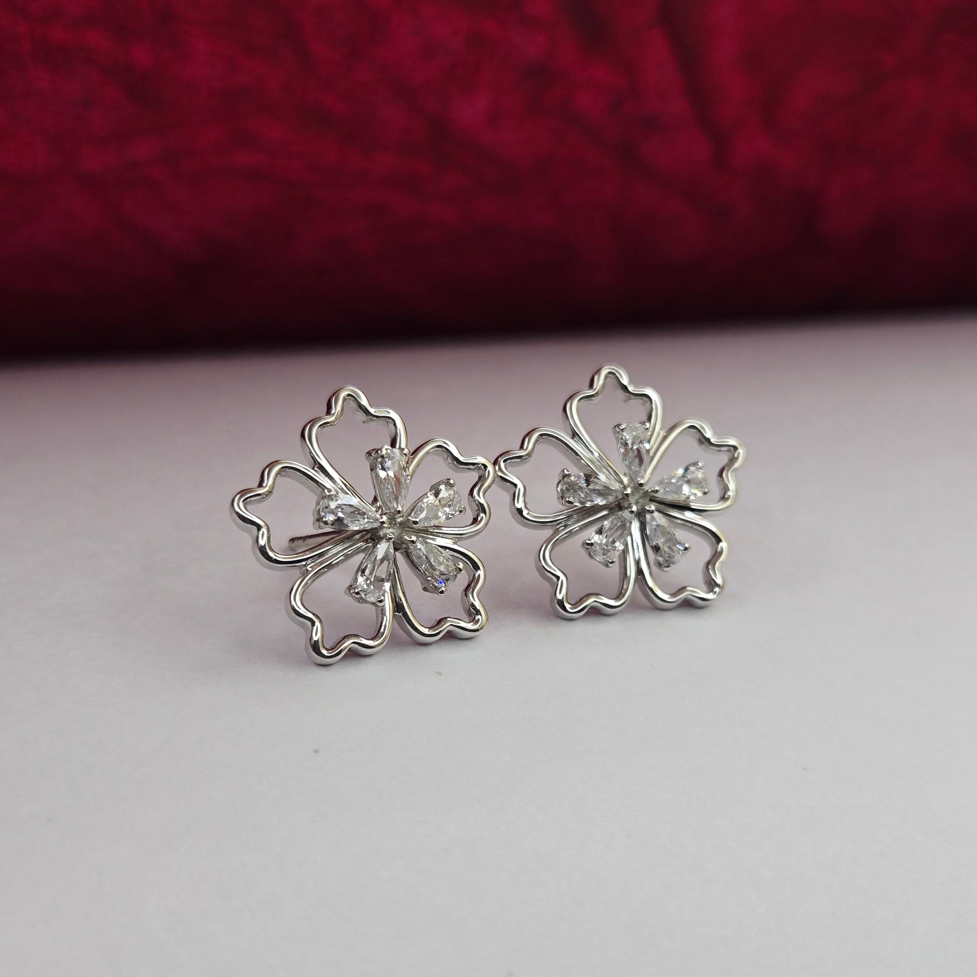 Rhodium-plated flower studs with shimmering crystal petals arranged in a symmetrical bloom design, suitable for both casual and festive styling
