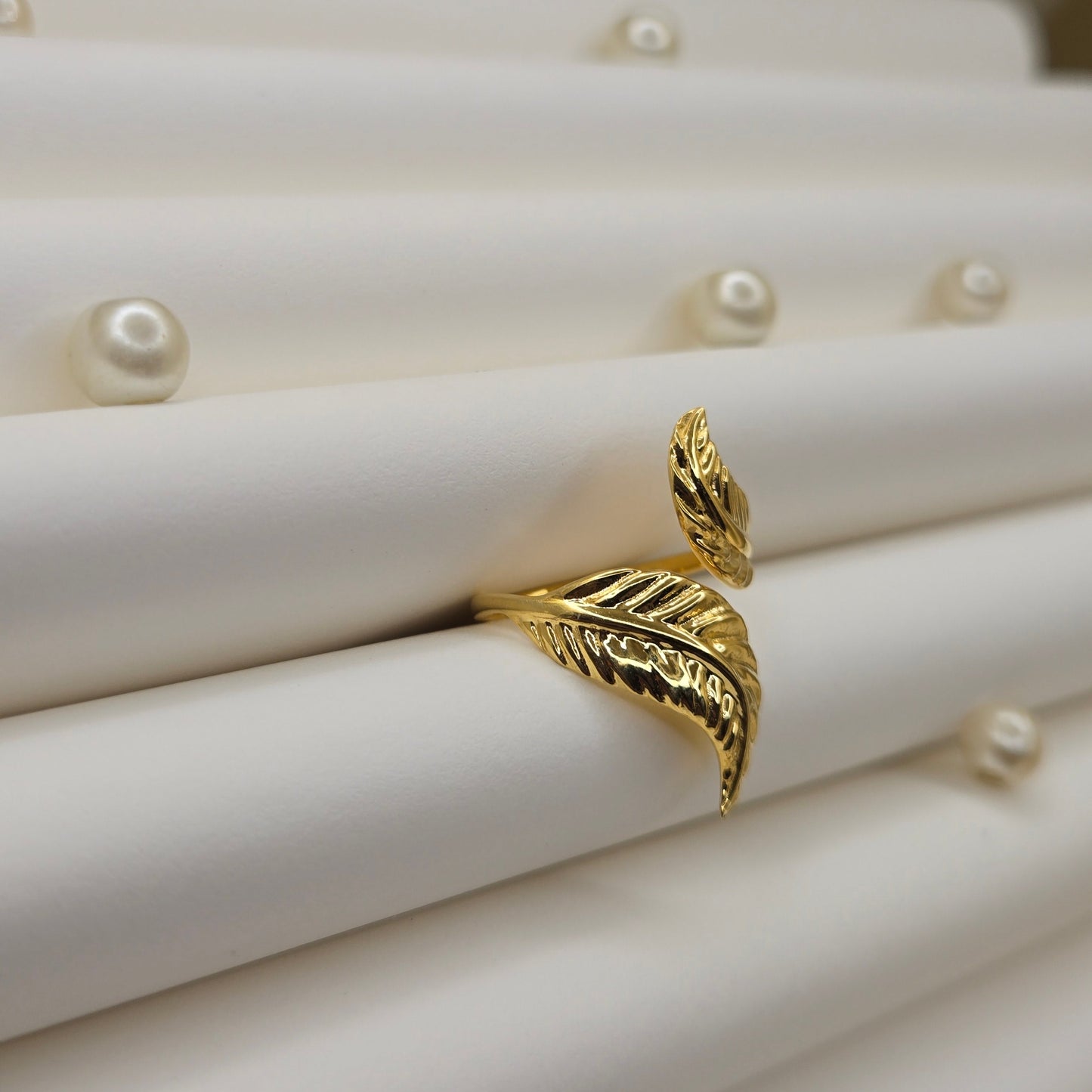 Elegant botanical-inspired ring with twin leaf accents, adjustable fit, and a polished gold tone, perfect for daily wear or stacking.