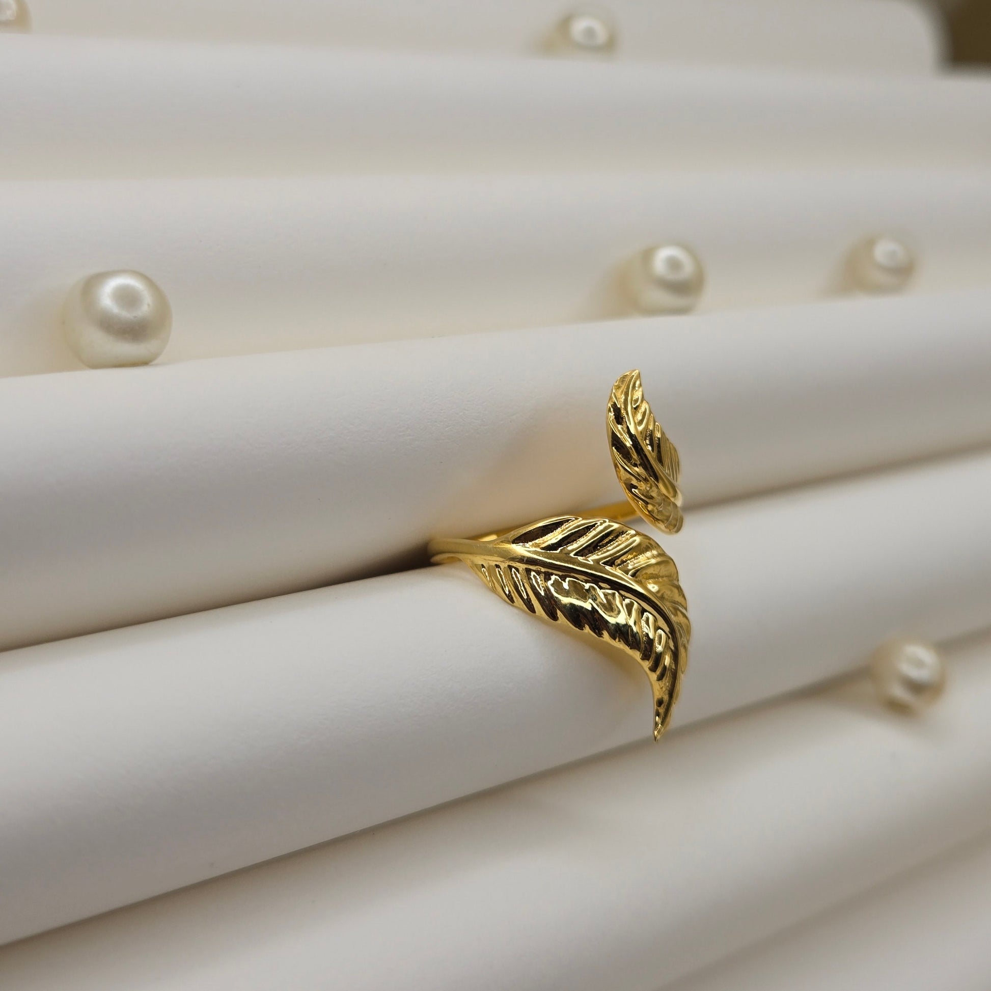 Elegant botanical-inspired ring with twin leaf accents, adjustable fit, and a polished gold tone, perfect for daily wear or stacking.