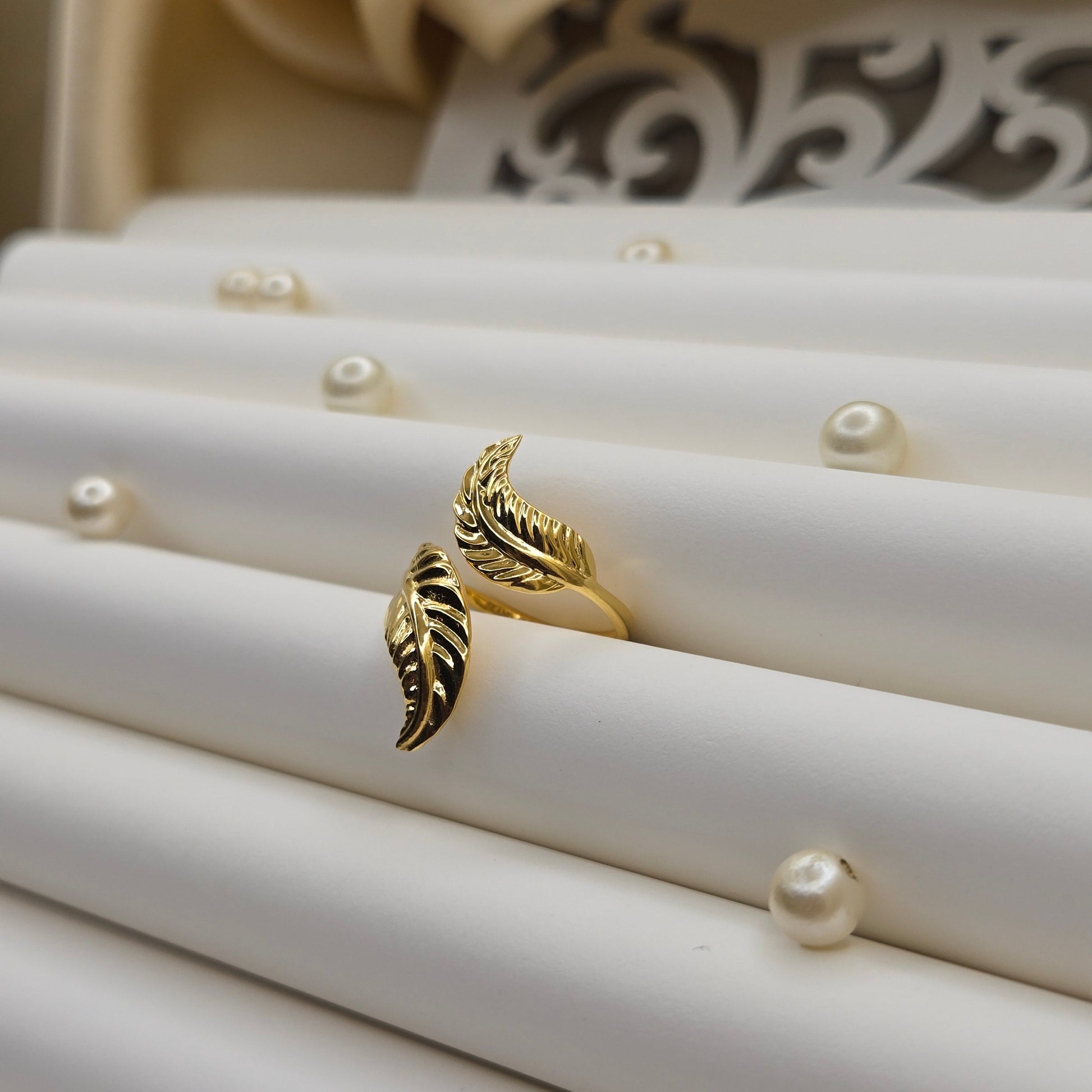 Elegant botanical-inspired ring with twin leaf accents, adjustable fit, and a polished gold tone, perfect for daily wear or stacking.