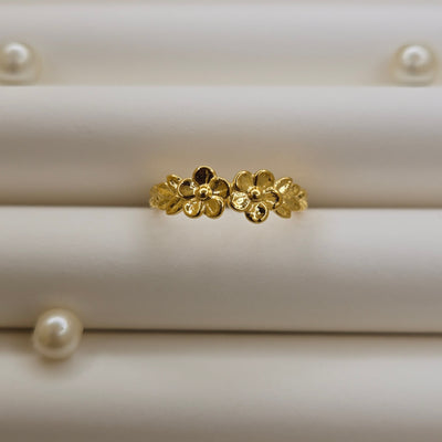 Minimalistic gold-tone flower band ring with smooth petal detailing, perfect for stacking or wearing as a subtle statement piece.
