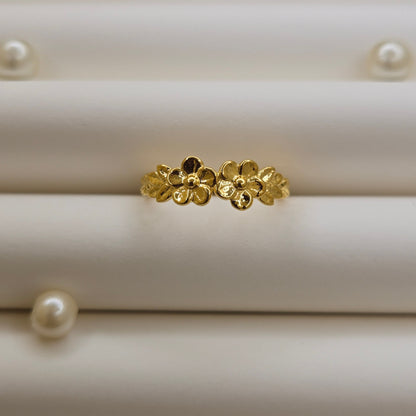Minimalistic gold-tone flower band ring with smooth petal detailing, perfect for stacking or wearing as a subtle statement piece.