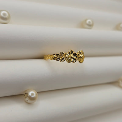 Minimalistic gold-tone flower band ring with smooth petal detailing, perfect for stacking or wearing as a subtle statement piece.