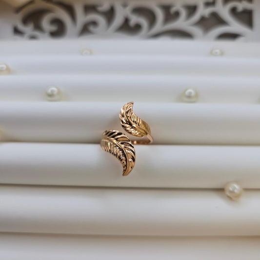 Elegant botanical-inspired ring with twin leaf accents, adjustable fit, and a polished rose-gold tone, perfect for daily wear or stacking.