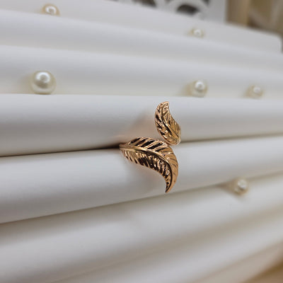 Elegant botanical-inspired ring with twin leaf accents, adjustable fit, and a polished rose-gold tone, perfect for daily wear or stacking.