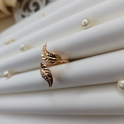 Elegant botanical-inspired ring with twin leaf accents, adjustable fit, and a polished rose-gold tone, perfect for daily wear or stacking.