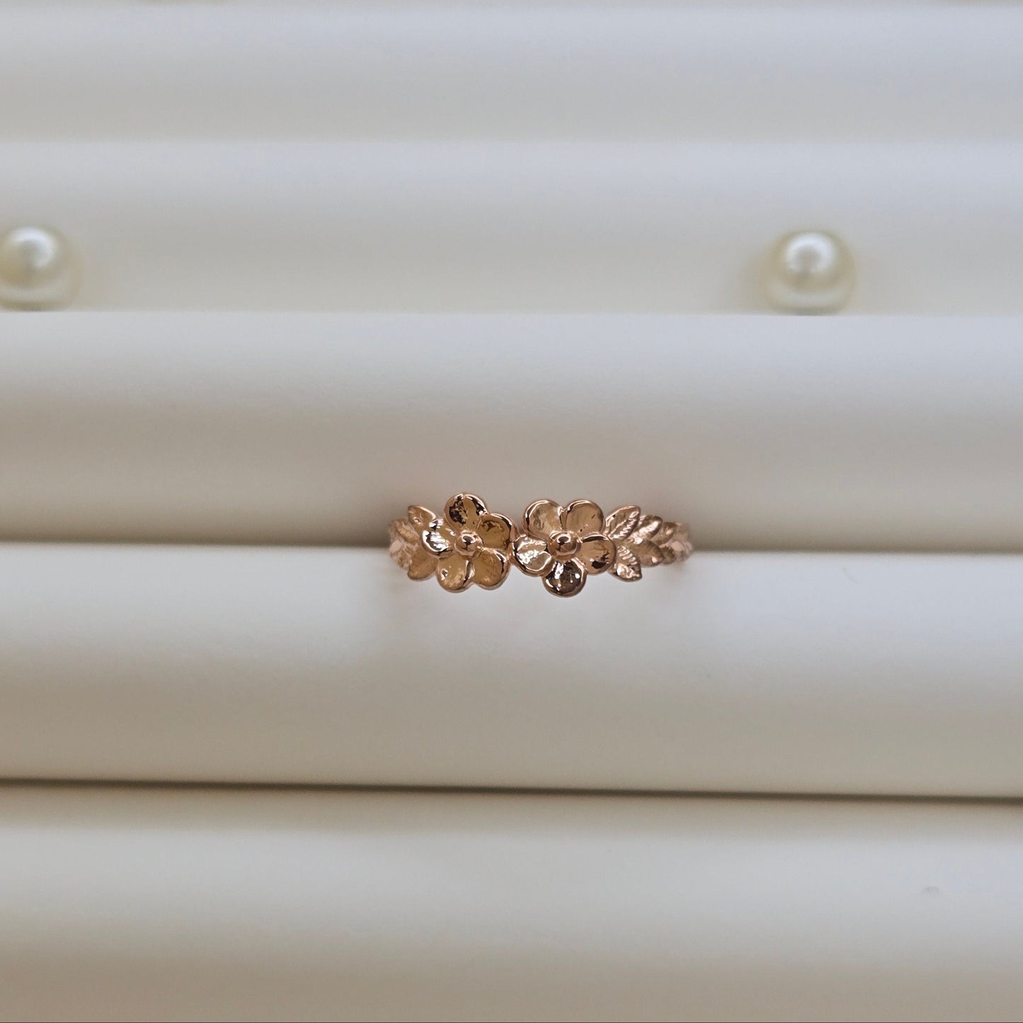 Minimalistic rose gold-tone flower band ring with smooth petal detailing, perfect for stacking or wearing as a subtle statement piece.
