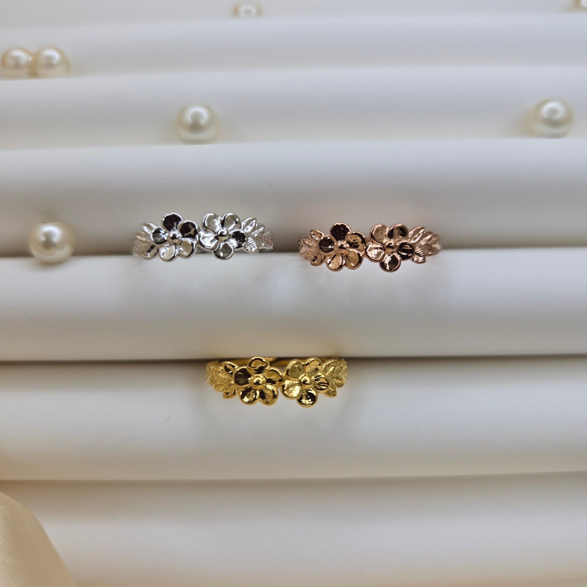 Minimalistic rose gold, gold and rhodium tone flower band ring with smooth petal detailing, perfect for stacking or wearing as a subtle statement piece.