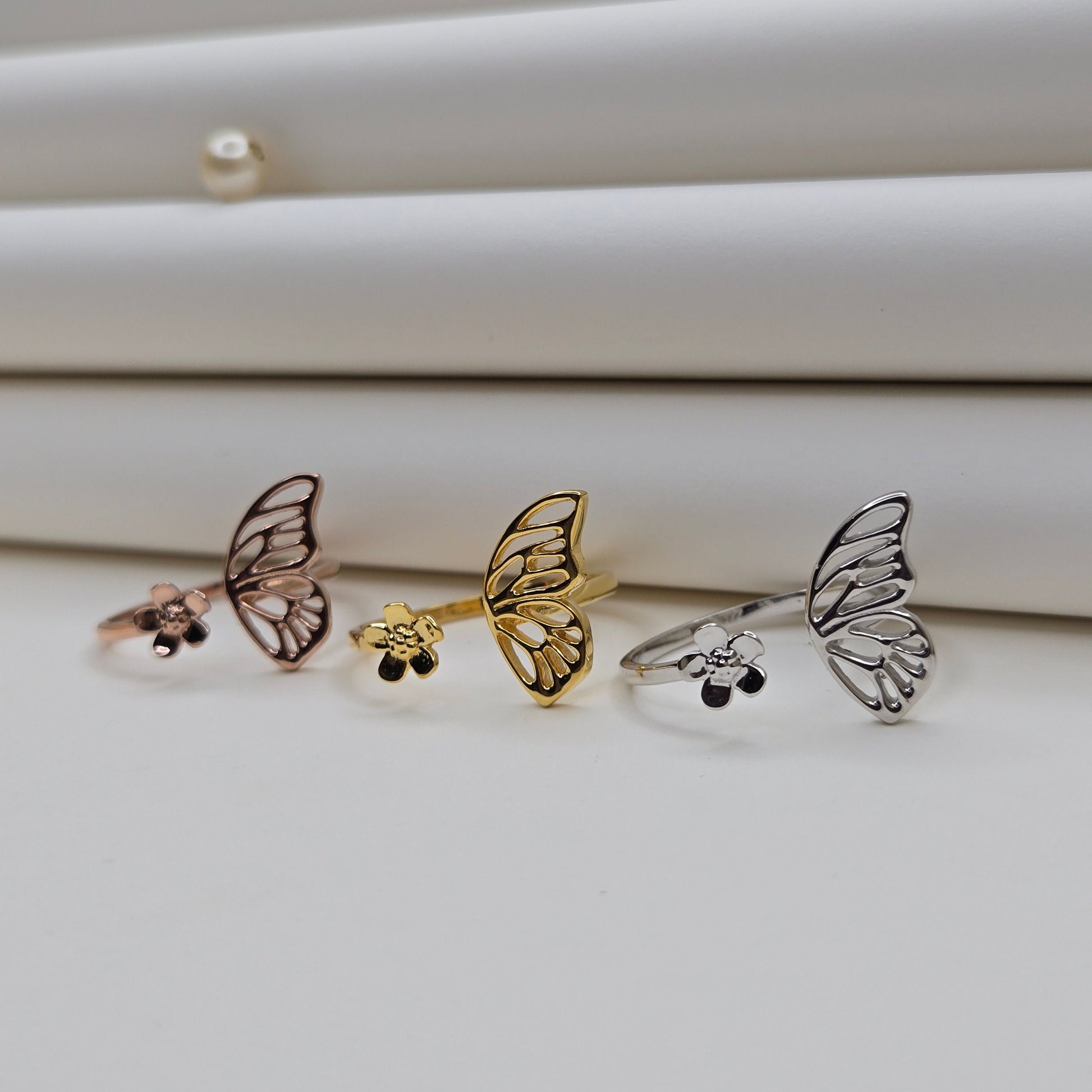 Butterfly wing and flower open band ring in polished gold, rose-gold and rhodium finish, offering a lightweight and artistic everyday statement look.