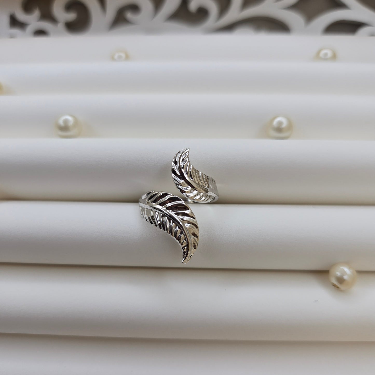 Elegant botanical-inspired ring with twin leaf accents, adjustable fit, and a polished rhodium stone, perfect for daily wear or stacking.